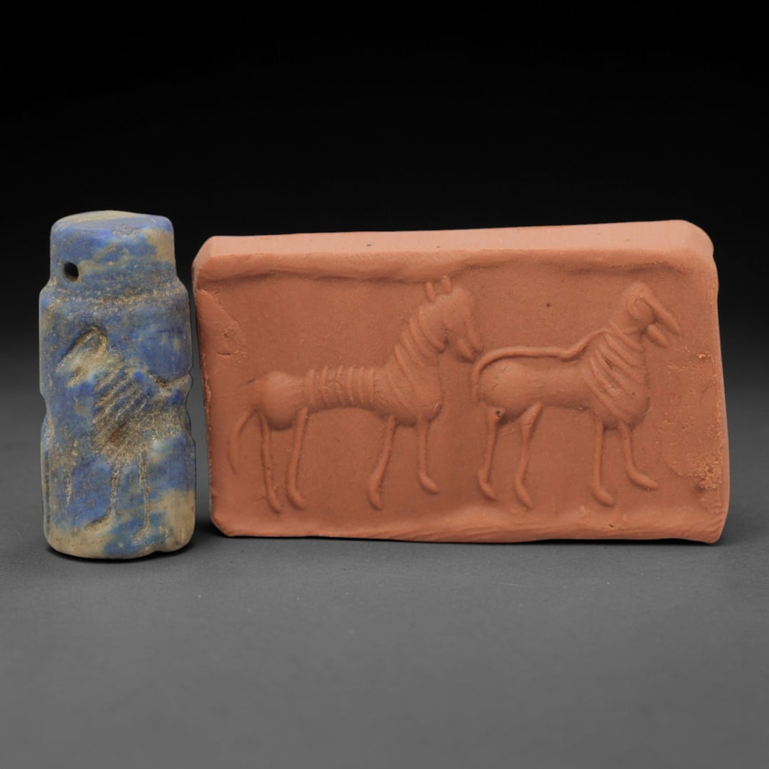 Ancient Lapis Lazuli Cylinder Seal - Near Eastern Glyptic Art, 47ZQ: Carved from lapis lazuli stone, this ancient Near Eastern cylinder seal features a cylindrical form with raised relief carvings depicting stylized human figures and geometric patterns. The seal exhibi