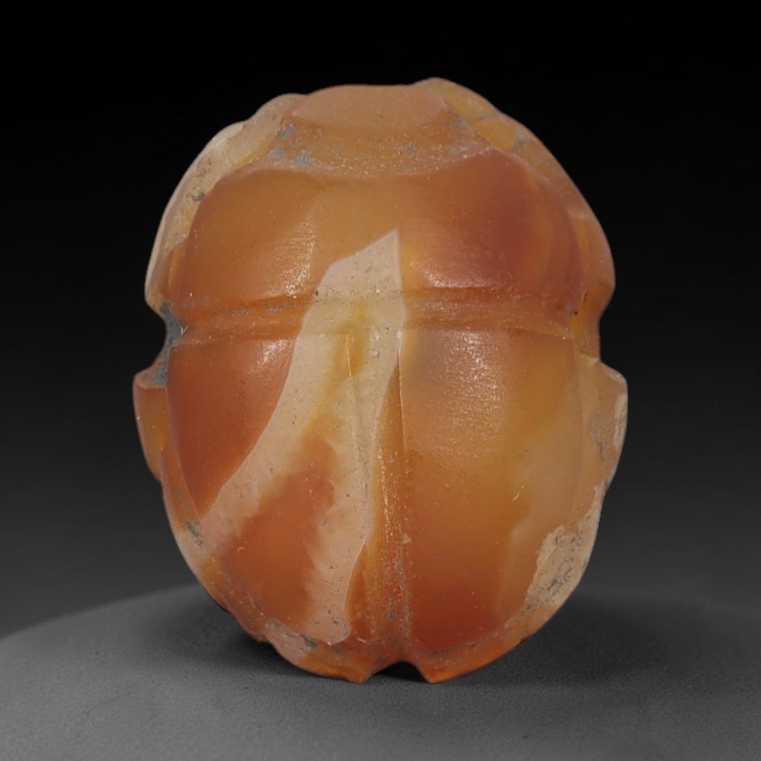 Ancient Banded Agate Scarab Amulet - Egyptian Figurine, 23AJ: Carved from warm banded agate with creamy white and amber-orange natural inclusions, this amulet is formed as a stylized scarab beetle with subtle linear detailing to define segmented wing cases and b