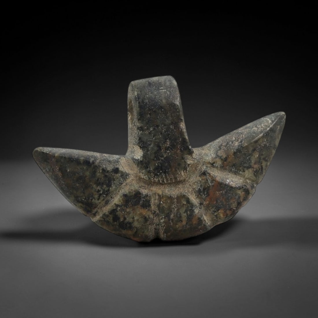 Ancient Serpentine Winged Amulet - Near Eastern Figurine, 12AJ: Carved from mottled dark serpentine with natural mineral inclusions, this amulet is formed as a stylized winged motif with a central vertical stem and two symmetrical pointed wing extensions, featurin