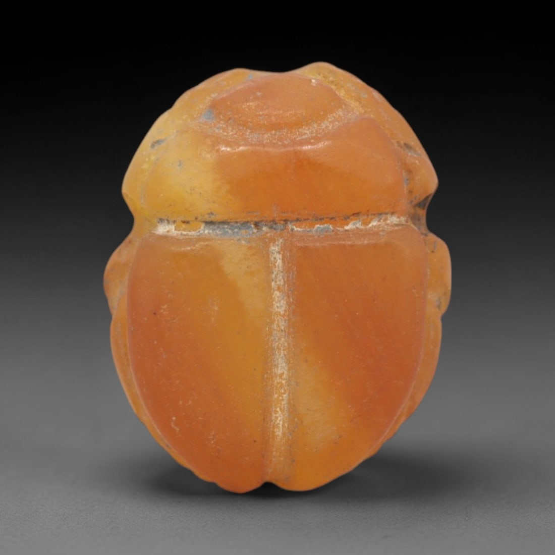 Ancient Agate Scarab - Egyptian Amulet Bead, 82XS: This amulet is carved from warm orange agate, exhibiting natural banding and a smooth, matte finish characteristic of ancient Egyptian glyptic craftsmanship. The form is a classic scarab beetle, with