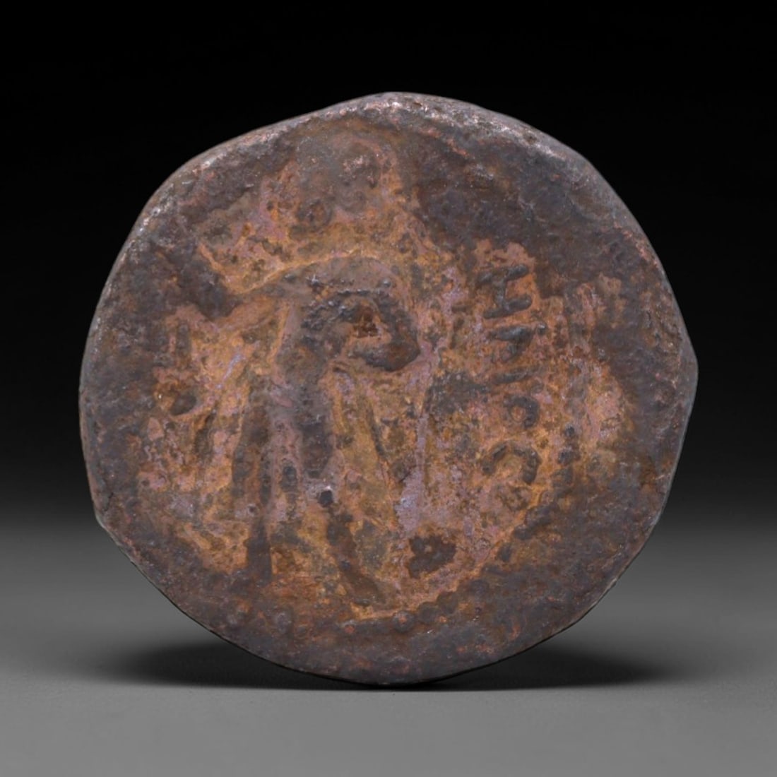 KUSHAN EMPIRE: Standing Deity Bronze Coin, 2nd-3rd Century, 20mm, 7.11g, 21XS: This compact bronze coin from the Kushan Empire captures the empire's role as a crossroads of faith, featuring a standing deity oriented to the left-an iconographic choice that reflects the syncretic