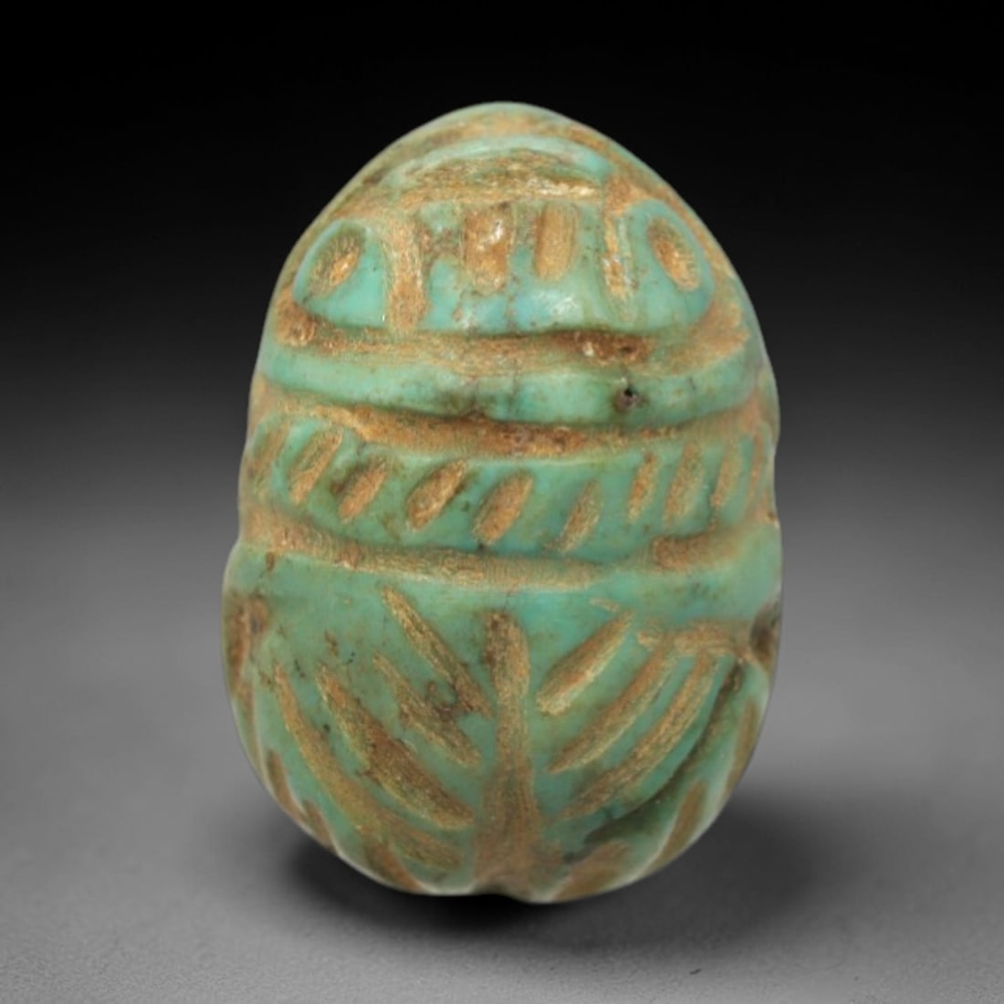 Ancient Turquoise Scarab - Near Eastern Amulet, 7XV: This artifact is a carved turquoise scarab, exhibiting hand-tooled relief detailing across its compact form. The dorsal surface features incised linear patterns evoking the elytra and wing structures