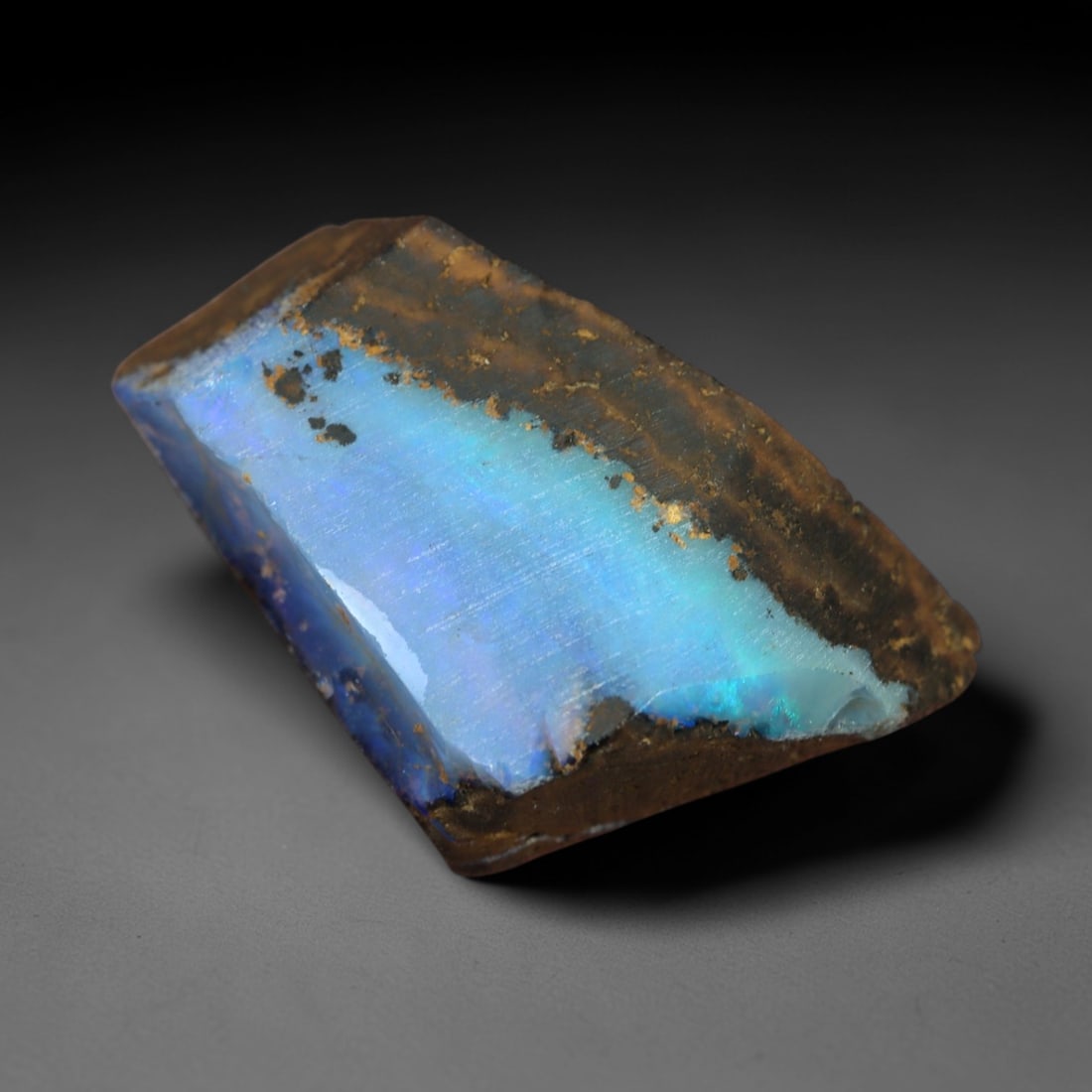 13.99 Carats Iridescent Sky Blue Winton Opal Rough - Natural Australian Specimen 17x14mm, 77XM: This exceptional rough opal from Winton, Australia, captivates with a vivid play of color, where intense flashes of sky blue and subtle turquoise swirl through a milky, translucent base. The natural,