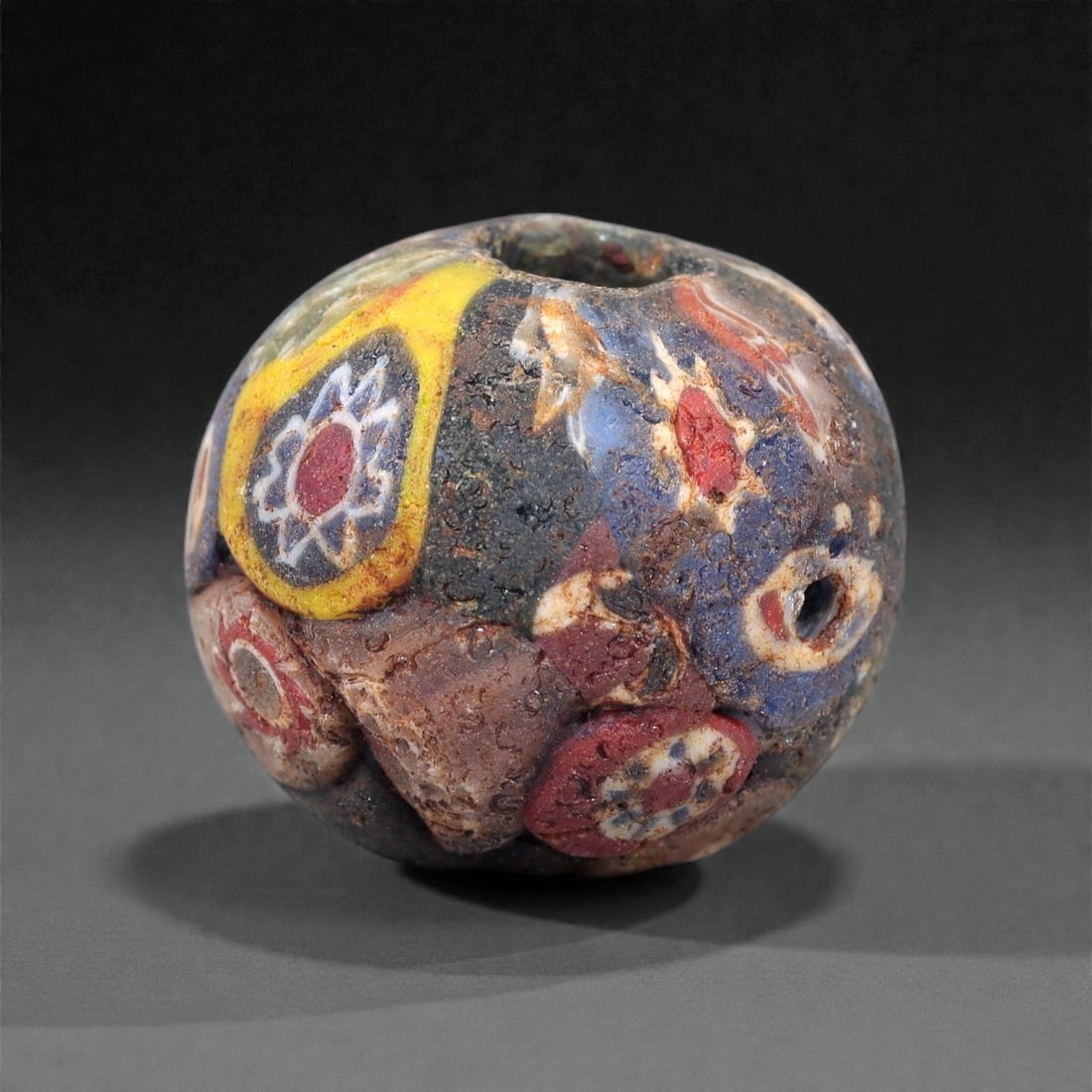Antique Glass Bead - Venetian Scramble Cane Sphere, 57Z: Formed of dense polychrome glass, this spherical bead was produced using the Venetian scramble cane technique, in which fragments of multicolored glass canes were irregularly arranged and fused into a