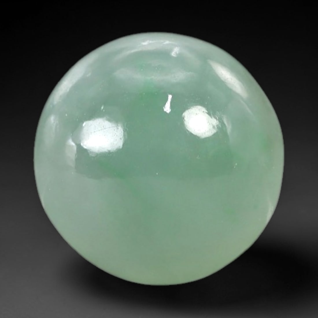 4.51 Carats Apple Green Jadeite Cabochon - Natural Burmese Stone, 81AB: This near-round jadeite cabochon features a variegated apple green hue, with subtle verdant inclusions distributed throughout a pale, semi-translucent matrix. The domed cabochon cut is executed to acc