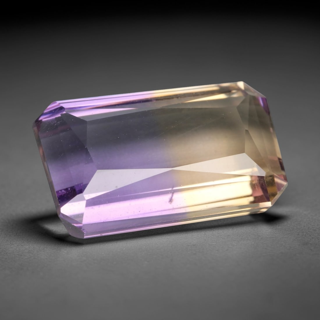 7.238 Carats Violet and Yellow Ametrine - Natural Brazilian Gemstone, LZ275: This impressive octagon step-cut ametrine showcases a striking, well-defined fusion of deep violet and warm golden-yellow hues, a hallmark of this dual-colored quartz. The step-cut faceting enhances t