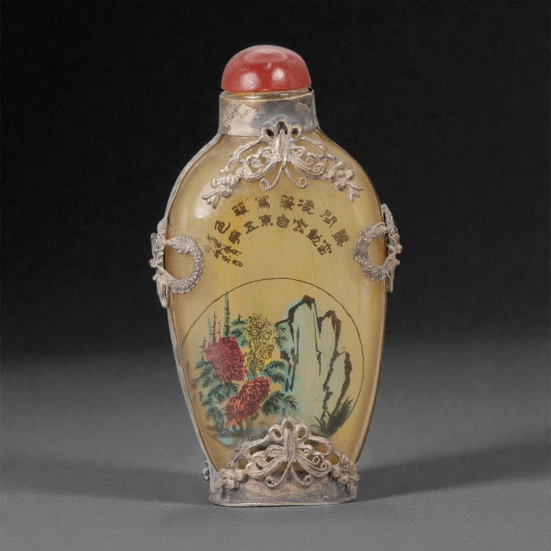 A Chinese Glass Inside-Painted Snuff Bottle with Metal Mounts, 20th Century, 32FG: The snuff bottle is formed from translucent amber-toned glass with an elongated ovoid body, a short cylindrical neck, and a flat recessed foot. The exterior is fitted with applied metal mounts in reli