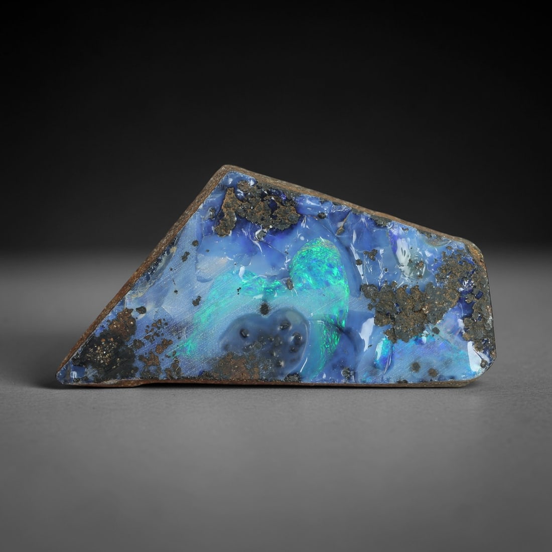 34.92 Carats Winton Boulder Opal Rough Slab - Natural Australian Stone, 42XP: This striking Winton boulder opal rough slab showcases a vivid, iridescent patch of emerald-green and electric-blue play-of-color, set against a soft sky-blue opal base and encased in a rugged ironsto