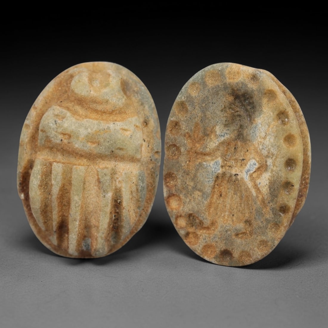 An Ancient Near Eastern Stone Scarab Stamp Seal, 1st Millennium BCE, 99AC: Carved from pale, weathered stone with natural surface encrustation and subtle tonal variation, the object is formed as an oval scarab seal. The dorsal side is modeled in low relief with a segmented c