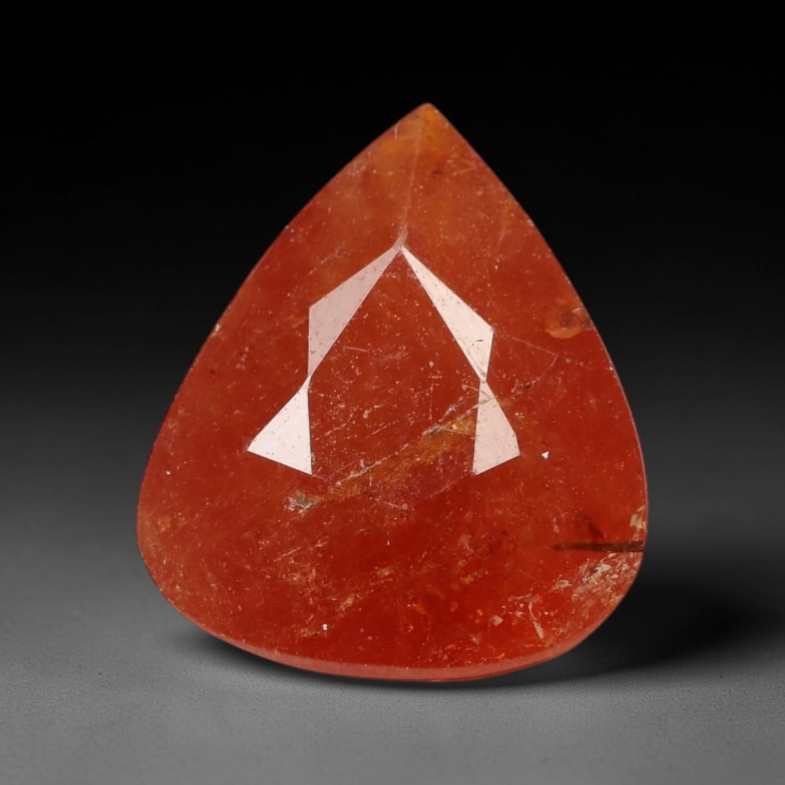 12.69 Carats Deep Orange Red Garnet Pear - Natural Mozambican Stone, 26XP: This singular pear-cut garnet radiates a warm, deep orange-red hue that evokes the glow of embers at dusk, its saturated color pulsing with life under natural and artificial light. The faceting patter