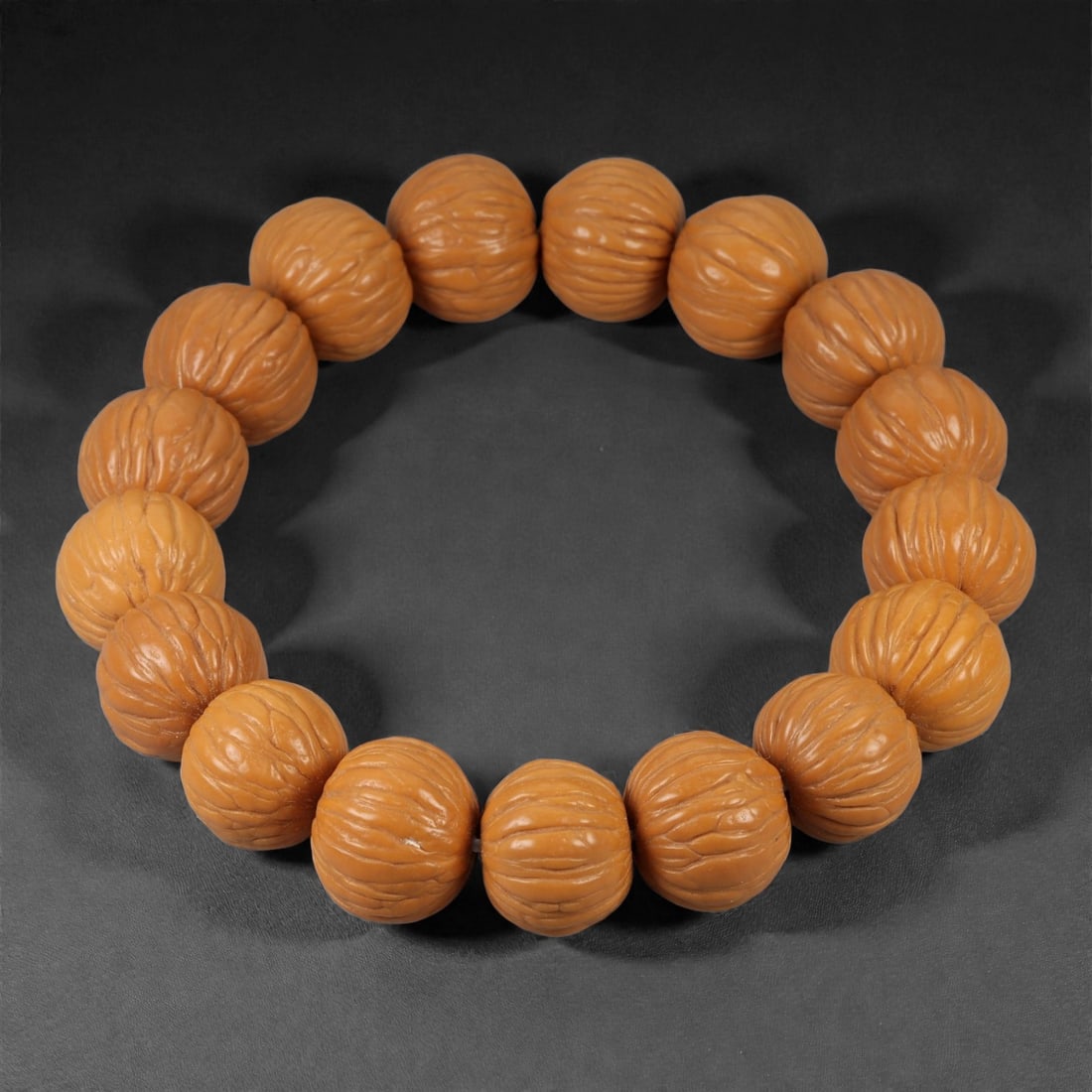 A Seed Bead Bracelet, 20th-21st Century, 73YB: Composed of a continuous strand of rounded natural seed beads, drilled and strung to form a circular bracelet. Each bead is uniformly shaped and carved to emphasize the natural ribbed surface of the s
