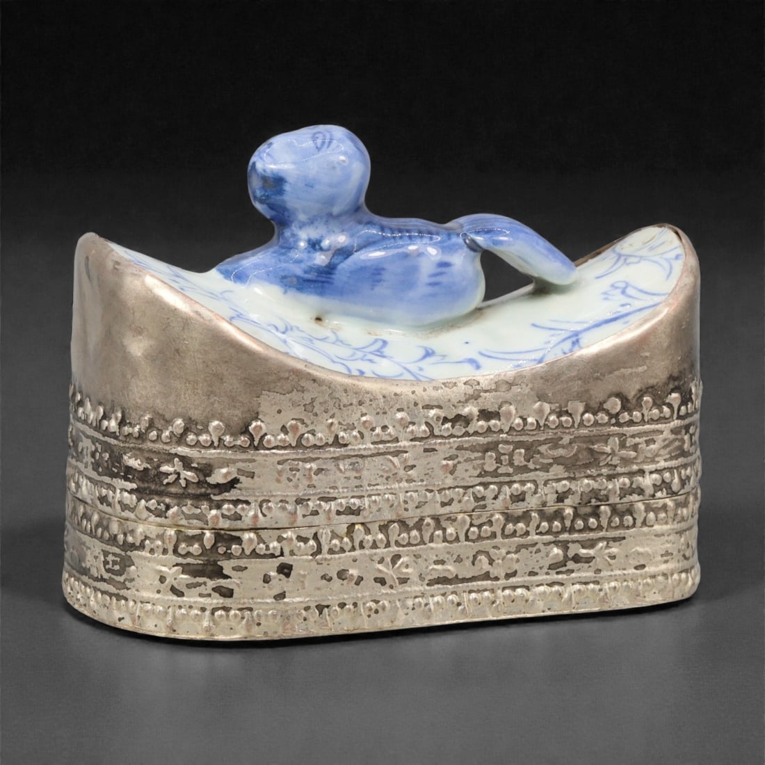 A Chinese Silvered Metal and Porcelain Trinket Box, 20th Century, 93YC: Constructed with a silvered metal exterior and a fitted porcelain insert, the trinket box is formed as a low rectangular container with rounded corners and a hinged or lift-off cover. The metal casing