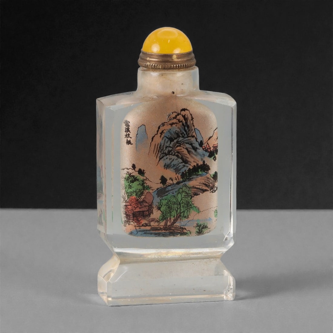 A Chinese Crystal Glass Inside-Painted Snuff Bottle, 20th Century, 55FG: The snuff bottle is formed from clear crystal glass and of flattened rectangular section, set on a stepped rectangular foot and rising to a short cylindrical neck with a flat rim. The interior is pain