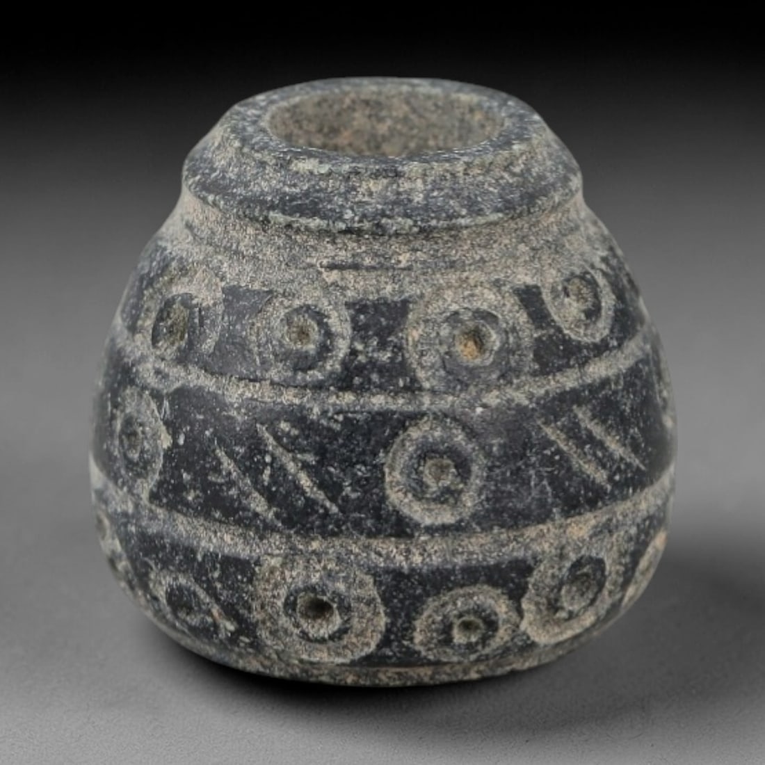 Ancient Bone Spindle Whorl - Near Eastern Radial Dot Motif, 92AH: This ancient Near Eastern spindle whorl is crafted from bone, featuring a convex form with a central perforation. The surface is incised with radial dot motifs arranged in concentric bands, a decorati