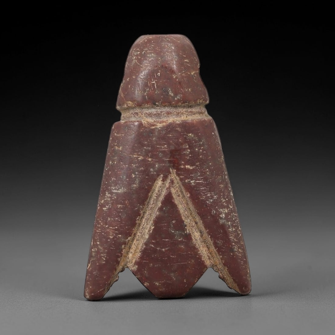 Ancient Egyptian Stone Amulet - Geometric Carved Pendant, 32AE: Carved from reddish-brown stone, this ancient Egyptian amulet features a triangular, tapering form with a suspension loop at the top, a design typical of protective amulets. Craftsmanship is simple ye