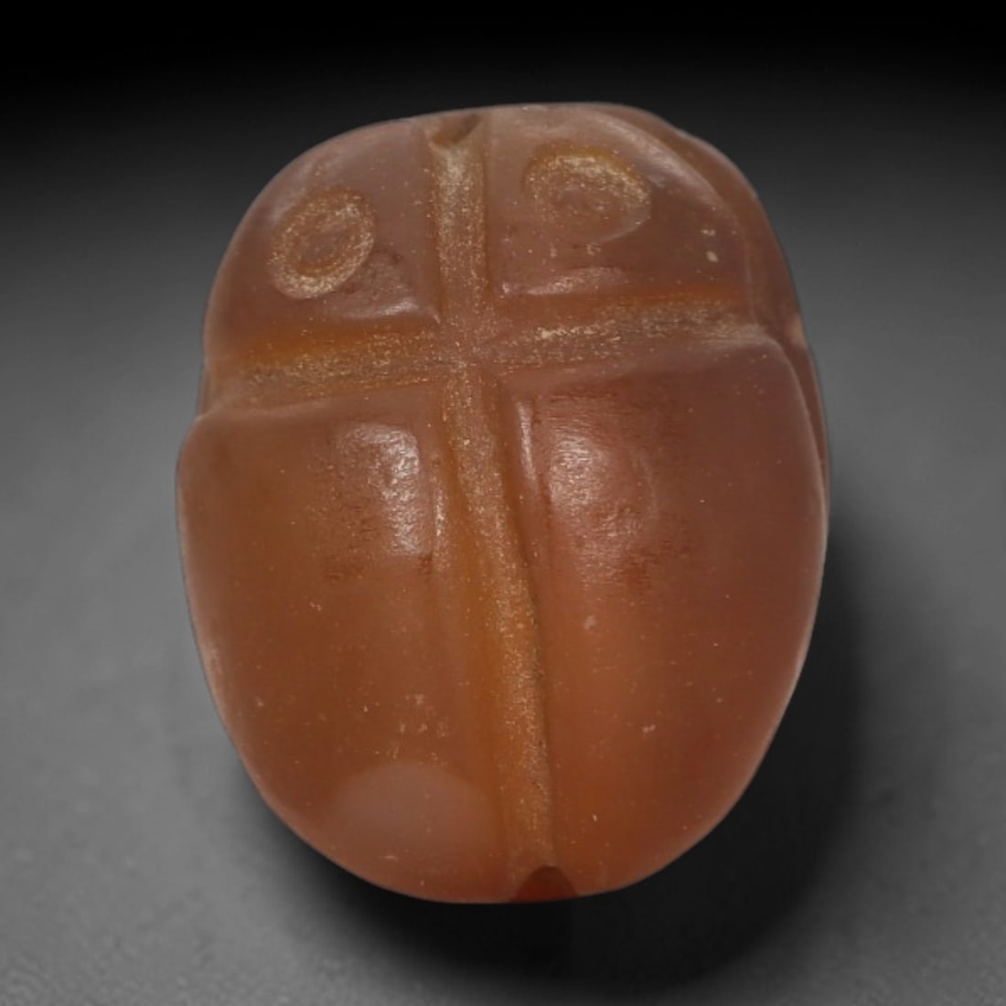 Ancient Chalcedony Scarab Amulet - Egyptian Figurine, 44AJ: Carved from smooth, warm amber chalcedony, this amulet is formed as a stylized scarab beetle with incised linear detailing to define a cross-shaped body pattern and circular decorative motifs, consist