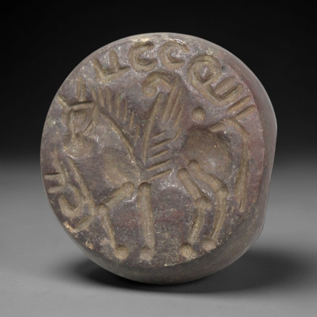 Ancient Stone Hemispherical Stamp Seal - Near Eastern Animal & Script, 32ZP: Crafted from a dense, reddish-brown stone, this hemispherical stamp seal bears a deeply incised composition featuring a stylized winged quadrupedal animal, rendered in linear relief with distinct wing