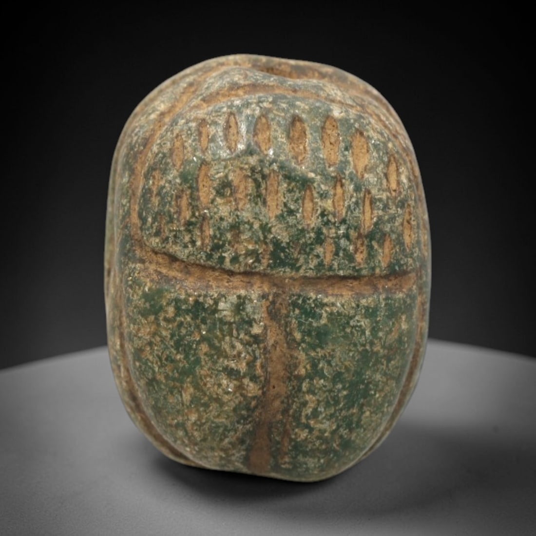 Ancient Egyptian Serpentine Scarab - Amulet Figurine, 48ZR: This artifact is a carved serpentine scarab amulet, crafted from a mottled green serpentine stone with a textured, weathered surface and earthy patina filling the incised details. The dorsal side feat