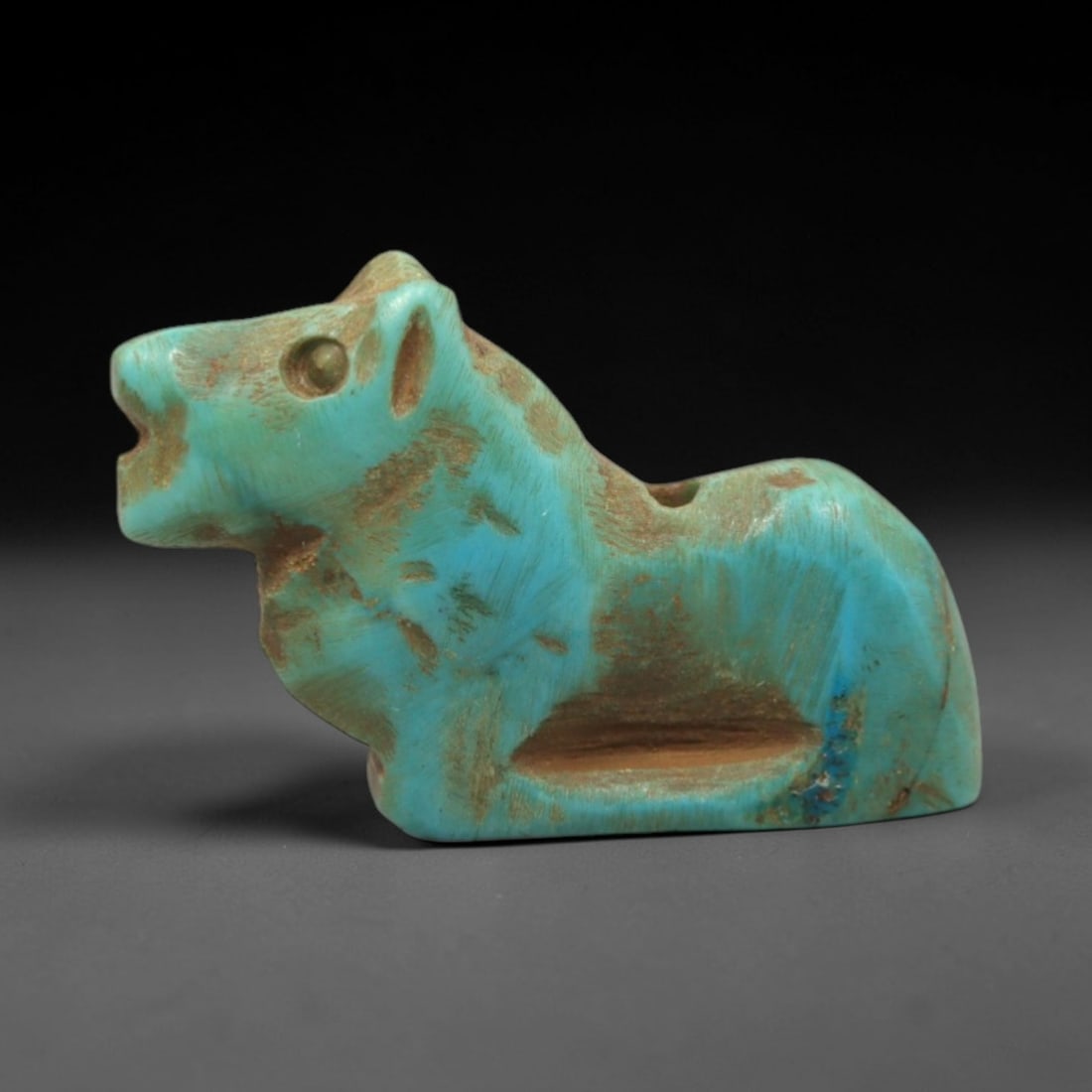 Ancient Turquoise Horse Amulet - Egyptian Animal Figurine, 12ZS: This artifact is a carved turquoise horse amulet, crafted in the stylized zoomorphic tradition of ancient Egypt. The amulet depicts a recumbent horse with simplified anatomical features, including a p