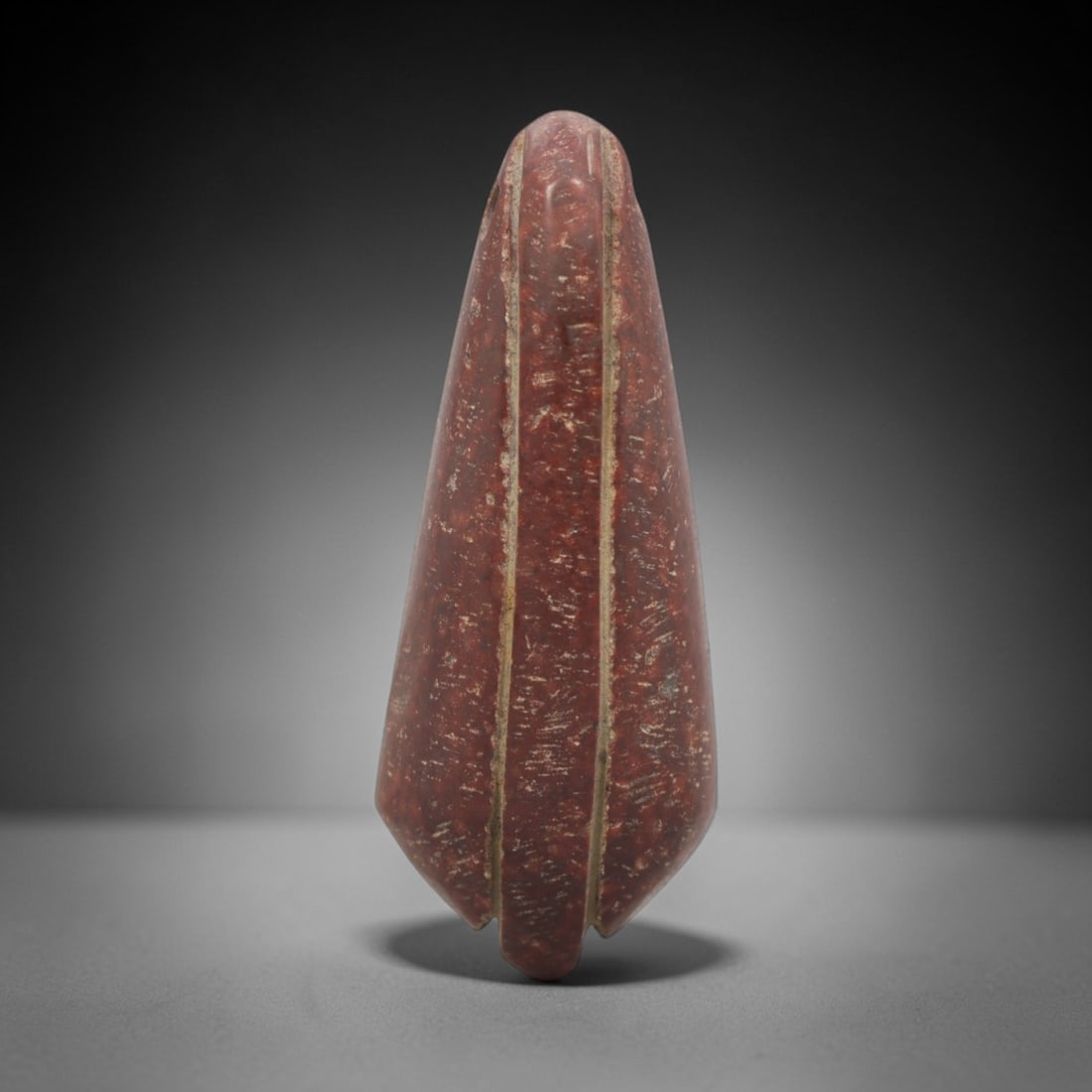 Ancient Near Eastern Red Stone Bud Amulet - Carved Pendant Figure, 6ZV: This amulet is carved from a rich, reddish-brown stone with natural speckling, likely brecciated jasper or red steatite, with incised linear details defining its stylized bud form. The piece features