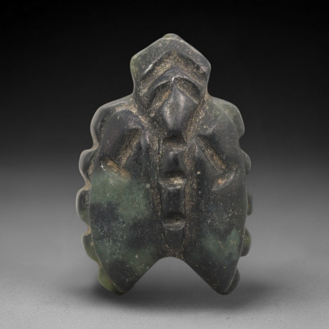 Ancient Jadeite Fly Amulet - Egyptian Animal Figure, 70ZW: This amulet is carved from mottled dark green and black jadeite, depicting a stylized fly with a geometric head, segmented body, and angular wing cases. Deep incised lines define the facial features,