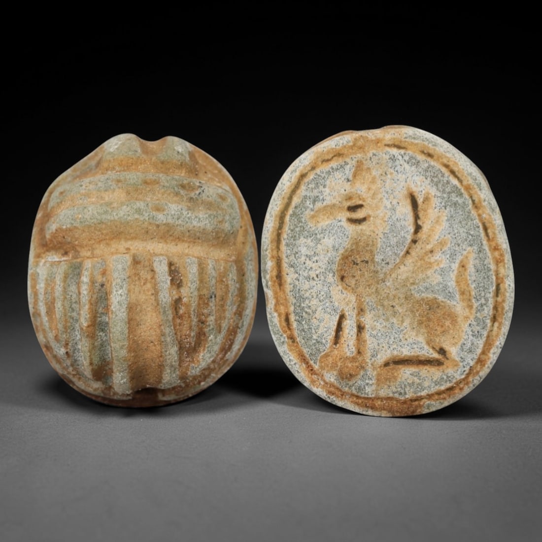 An Ancient Near Eastern Stone Scarab Stamp Seal, 1st Millennium BCE, 12ZM: Carved from pale, weathered stone with natural surface encrustation and subtle tonal variation, the object is formed as an oval scarab seal. The dorsal side is modeled in low relief with a segmented c