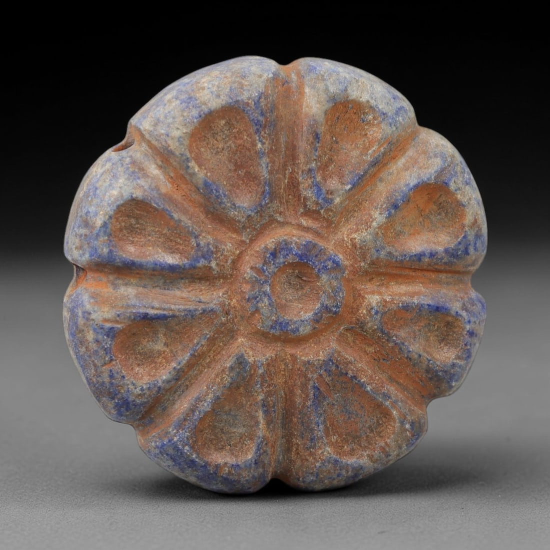 Ancient Lapis Bead - Achaemenid Amulet, 26AH: Carved from lapis lazuli, this ancient Achaemenid lapis bead features a lobed form with symmetrical detailing typical of Achaemenid glyptic art. The material exhibits deep blue coloration with natural
