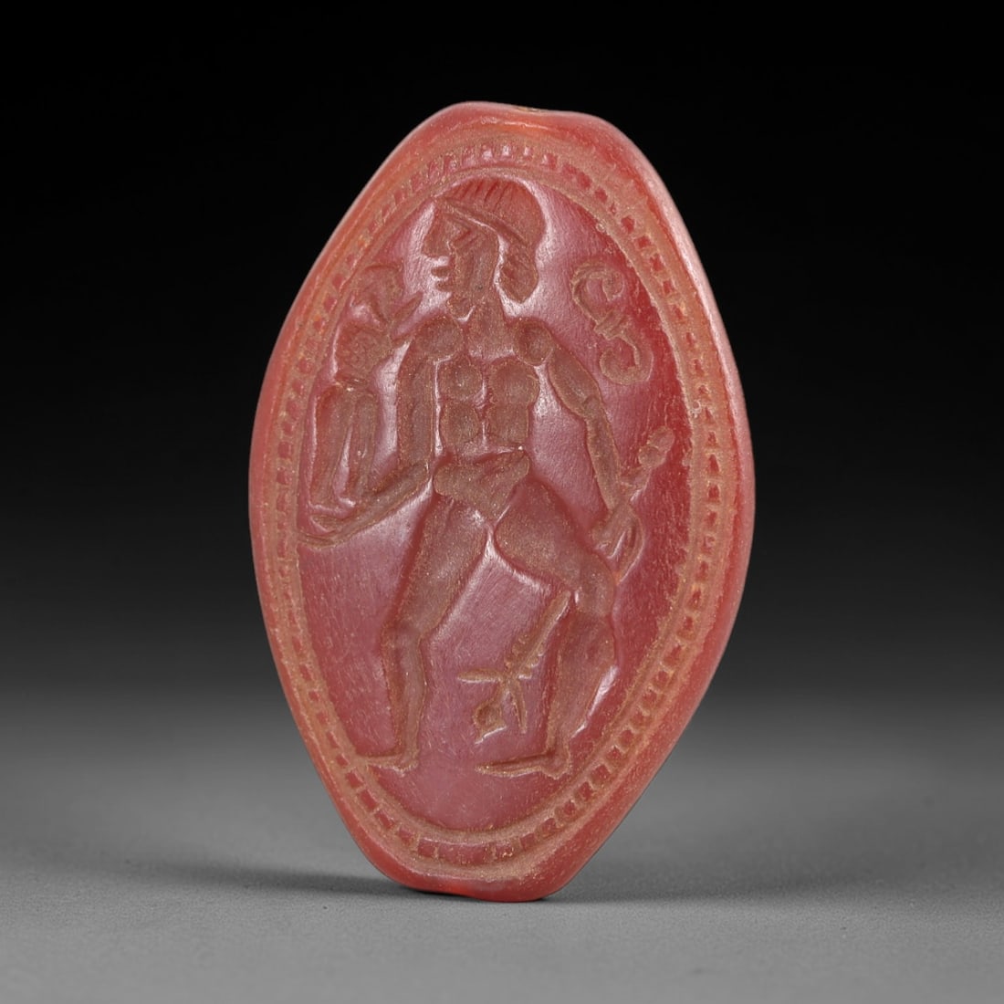 Ancient Carnelian Intaglio - Classical Hero Figure Amulet, 17AL: Crafted from rich red carnelian, this elongated oval intaglio bears a deeply incised depiction of a nude classical hero figure, likely Herakles (Hercules), holding a small captive figure in one hand a