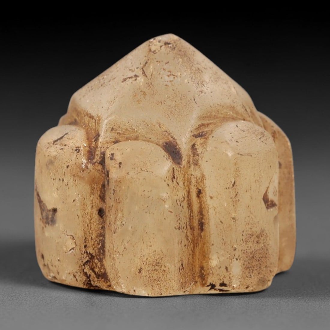 Ancient Rock Crystal Relic - Near Eastern Figurine, 64AL: This artifact is carved from translucent rock crystal, featuring a geometric, multi-faceted form with a pointed apex and cylindrical side segments. The crystal exhibits a natural, aged patina with sub