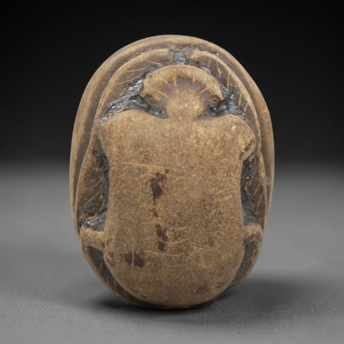 Ancient Egyptian Steatite Scarab - Amulet Figurine, 51ZR: This artifact is a carved steatite scarab amulet, fashioned from a fine-grained, pale tan stone with a matte, slightly porous surface and a natural earthy patina concentrated in the incised grooves. T