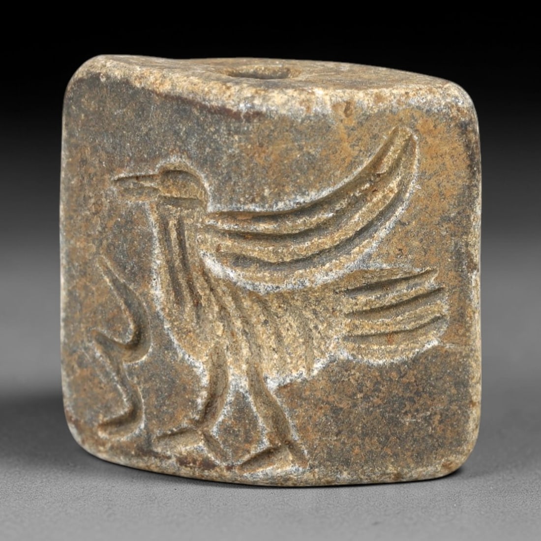 Ancient Schist Double Convex Bead Amulet - Near Eastern Avian Figure Intaglio, 69AM: Carved from dark gray schist, this 2.5x2cm double convex bead amulet features two nearly identical intaglio motifs: each side depicts a striding avian figure (likely an eagle or sacred bird) with outs