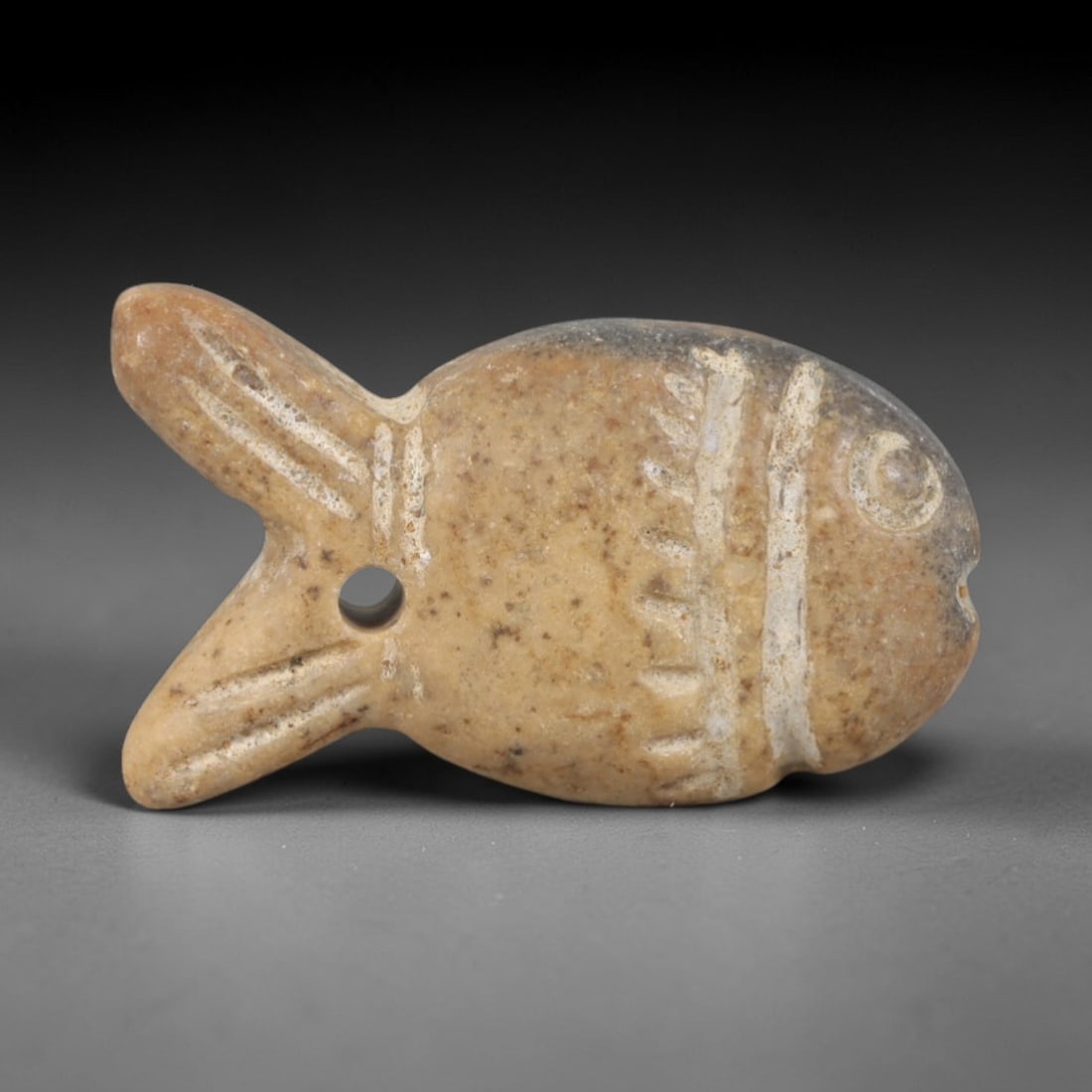 Ancient Steatite Fish Amulet - Egyptian Ritual Pendant, 65AR: Carved from steatite with natural tonal variation, this fish amulet follows the stylized form characteristic of ancient Egyptian protective iconography. The piece features incised linear details defin