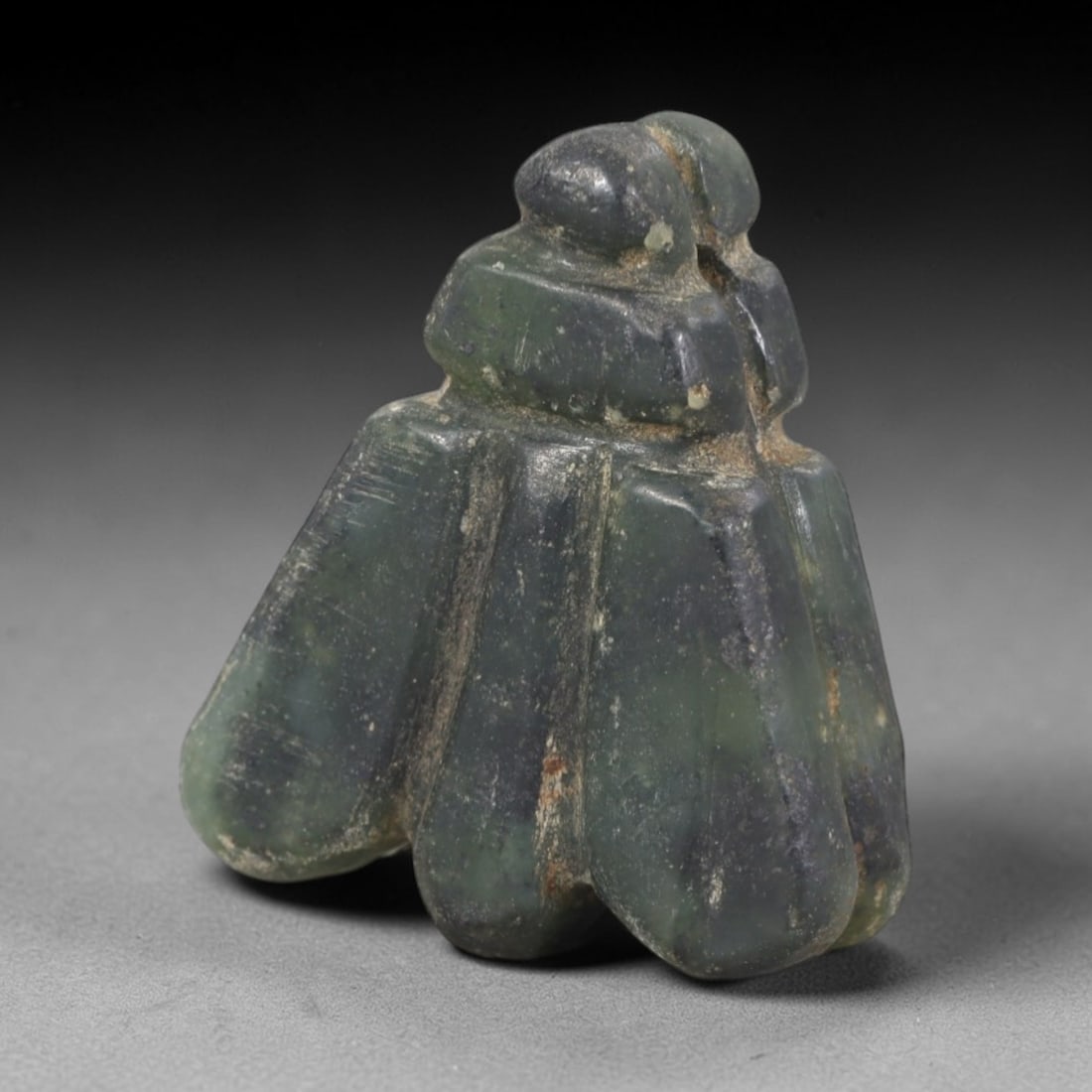 Ancient Jade Fly Amulet - Egyptian Ritual Pendant, 49AR: Carved from mottled green jade, this fly amulet follows the stylized form characteristic of ancient Egyptian protective iconography. The piece features a compact, segmented body with broad, incised wi
