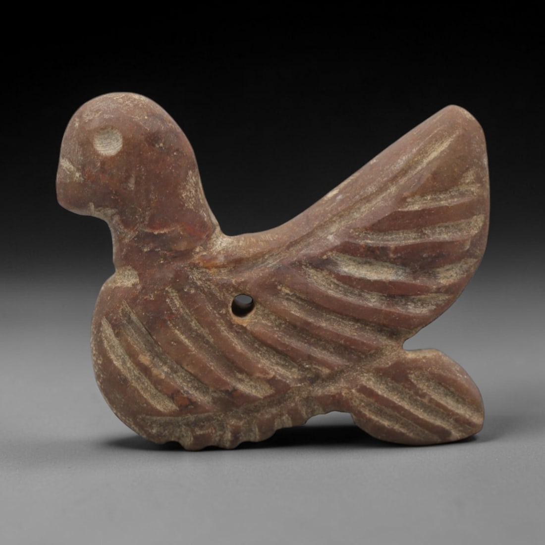 Ancient Near Eastern Red Stone Bird Amulet - Carved Pendant Figure, 33ZV: This amulet is carved from a rich, deep red stone with natural mineral speckling and patination, likely brecciated jasper or red steatite, featuring a stylized bird form. The piece displays a rounded