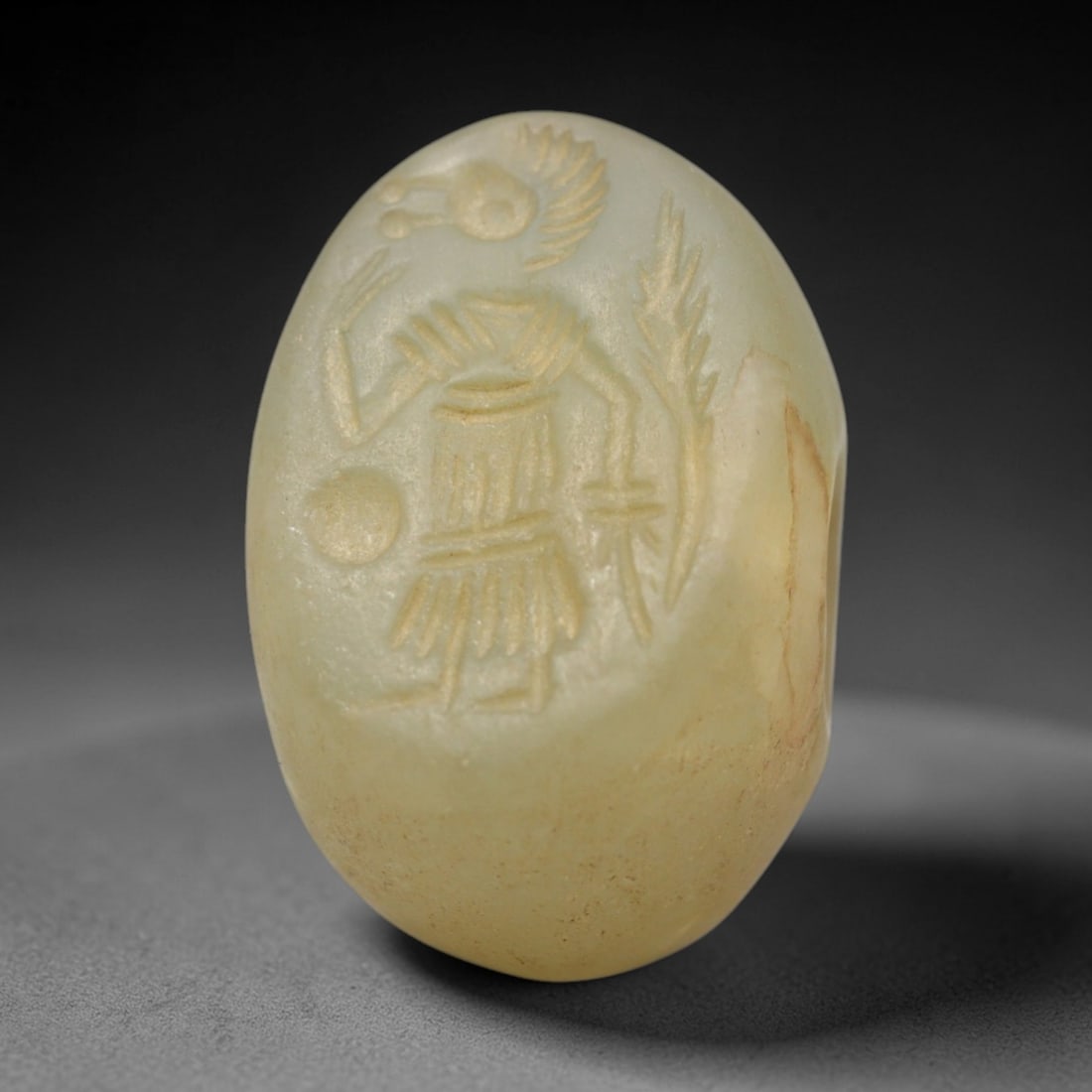 Ancient Serpentine Hemispherical Stamp Seal - Near Eastern Bird-Headed Hybrid Figure, 50ZS: Crafted from smooth, pale yellow-green serpentine stone, this hemispherical stamp seal bears incised carving of a mythical bird-headed hybrid figure, depicted with a stylized avian head, feathered hea