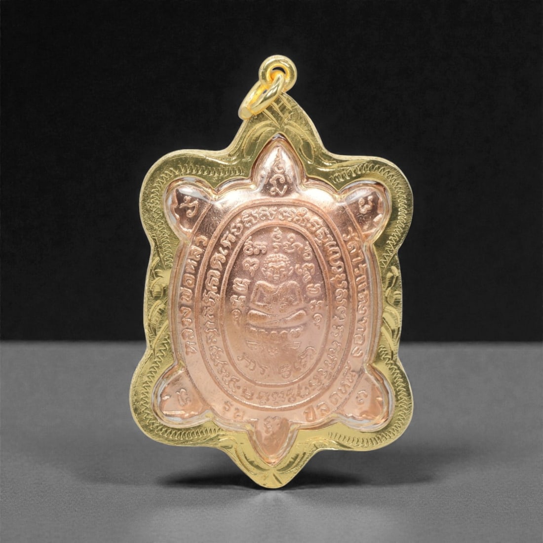 A Thai Copper Turtle Amulet in Gilt Metal Case, 20th Century, 87FN: Cast from copper, the amulet is shaped as a turtle. The obverse depicts a seated monk within an oval border, surrounded by Thai script characters. The reverse features a grid of symbolic motifs and ad