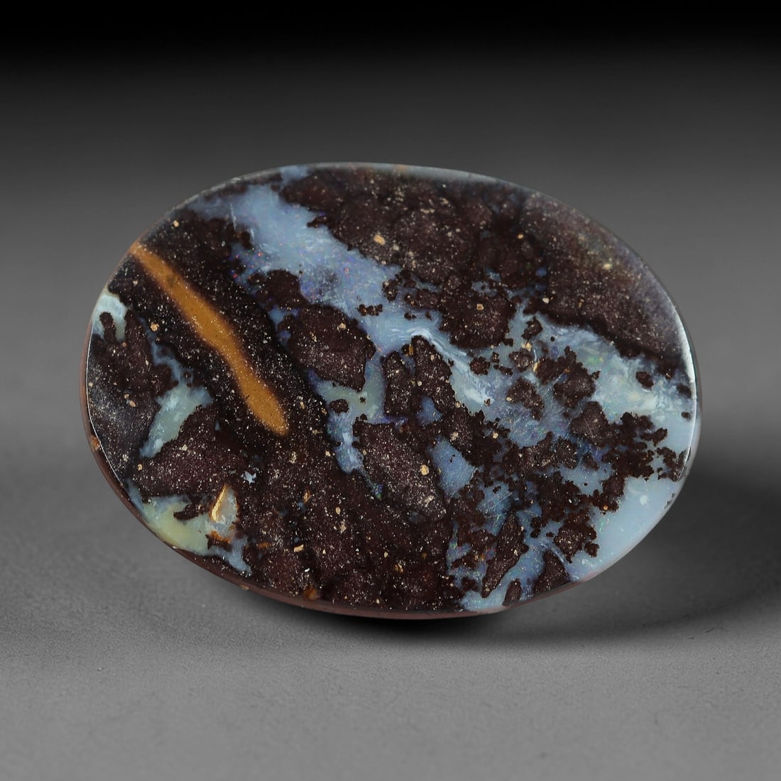 2.73 Carats Koroit Yowah Opal Cabochon - Natural Australian Single Stone, 86XL: This distinctive Koroit Yowah opal cabochon, measuring 12.9x9.5mm, features a striking, fragmented ironstone matrix in deep brown and black, interspersed with broad, milky-blue opal veins. A single, l