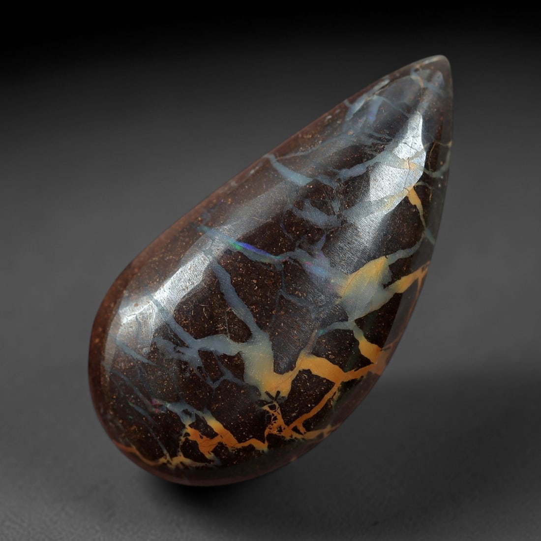 5.45 Carats Boulder Opal Cabochon - Natural Matrix Vein Specimen, 61XM: This 5.45ct boulder opal cabochon, measuring 18x9mm, is a striking example of Australia's iconic gemstone, showcasing the unique beauty of nature's artistry. The teardrop-shaped cabochon is polished t