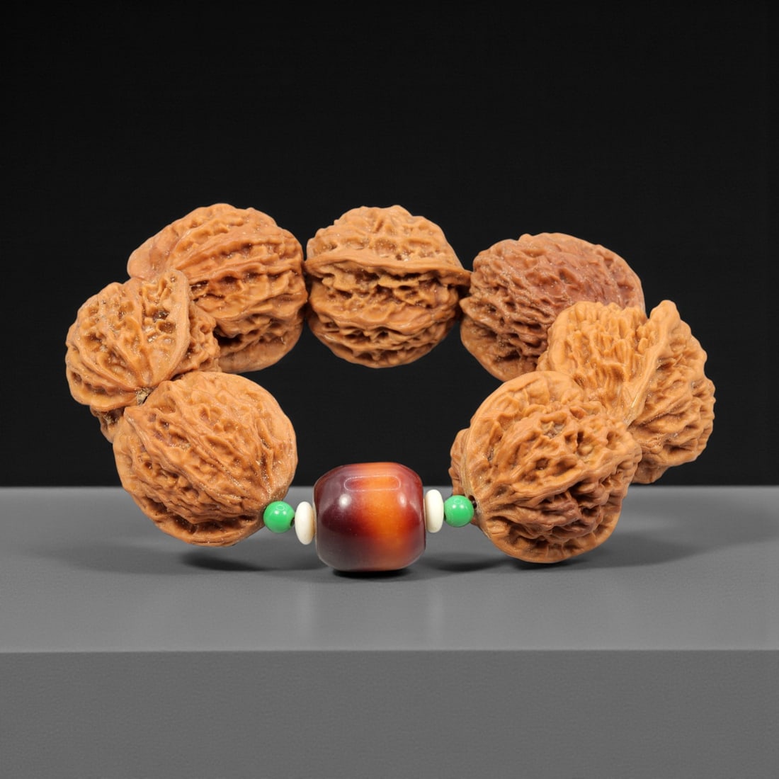 A Chinese Walnut Seed Bead Bracelet, 20th Century, 56YC: The bracelet is composed of a continuous strand of large natural walnut seed beads, each carved and selected to retain pronounced lobed forms and deeply textured surfaces characteristic of the shell s