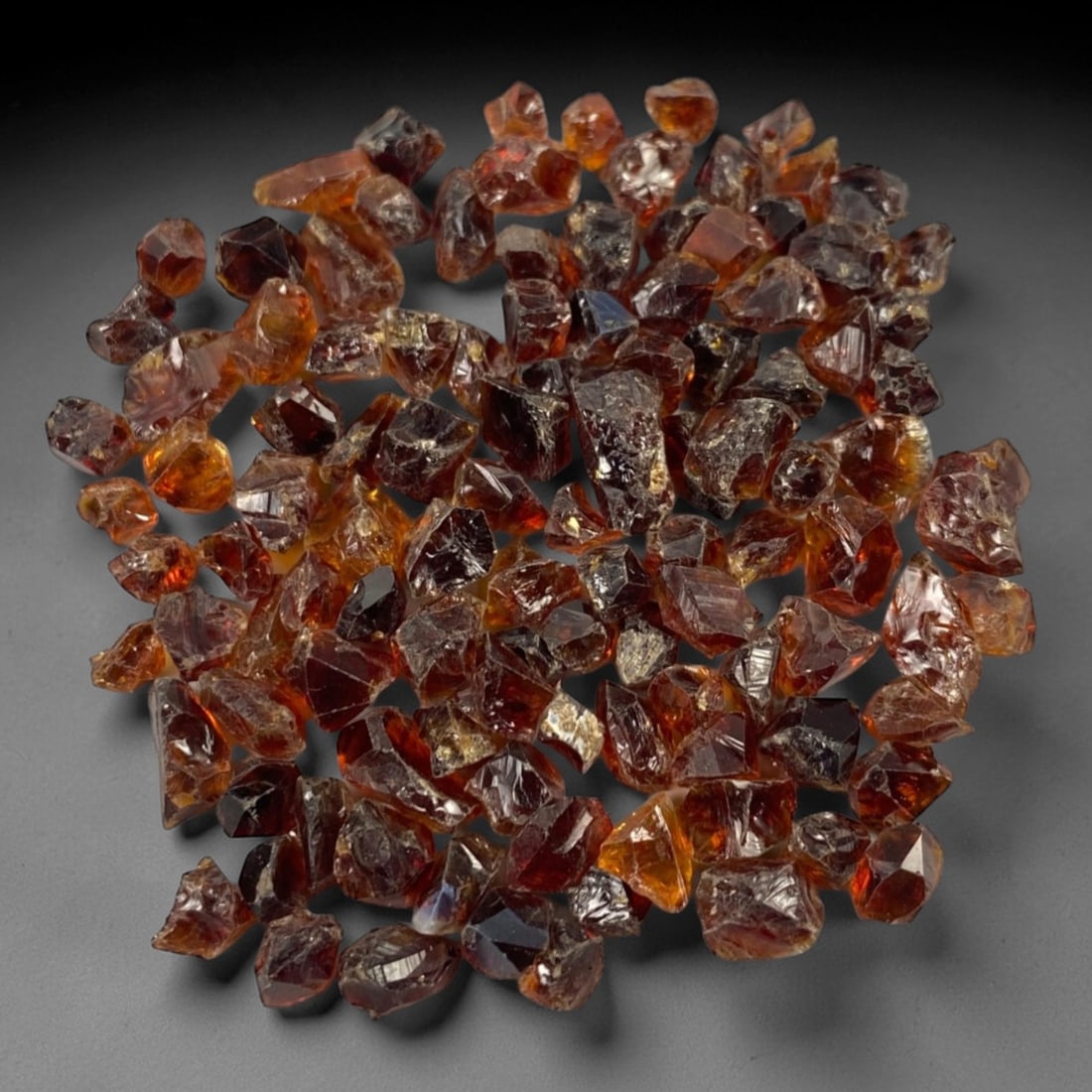 104.79 Carats Garnet Rough Parcel - Natural Loose Gemstones, 100ZL: This substantial parcel of garnet rough, weighing a total of 104.79 carats with individual pieces averaging 6.9 x 5.7 x 4.5 mm, showcases the gemstone's rich, warm color palette. The rough crystals di
