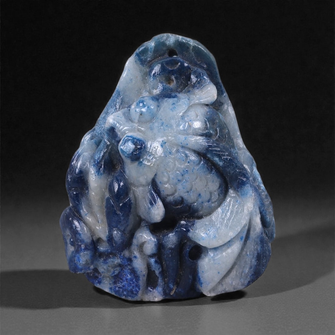 Glazed Fish Pendant - Carved Stone Amulet, 20WE, 20WE: Carved as a compact pendant and finished with a glossy blue glaze, this fish-form carving displays rounded modeling and softly articulated fins and body contours. The surface treatment combines carved