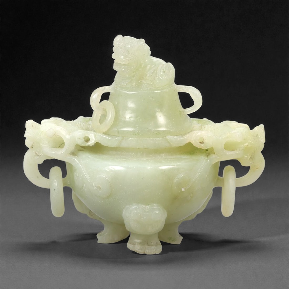A Chinese Hetian Jade Tripod Censer and Cover, 20th Century, 30FH: Carved from pale celadon-toned Hetian jade with light translucency and subtle natural inclusions, the vessel is formed as a covered tripod censer. The rounded body is raised on three short feet carved