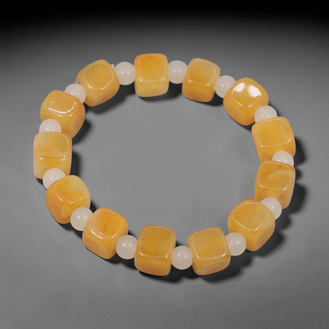 A Chinese Quartz Bead Bracelet, 20th Century, 88FS: Composed of cushion-shaped beads of warm golden-yellow quartz with natural tonal variations and minor internal inclusions, the bracelet is strung in a continuous loop. The beads feature a smooth, poli