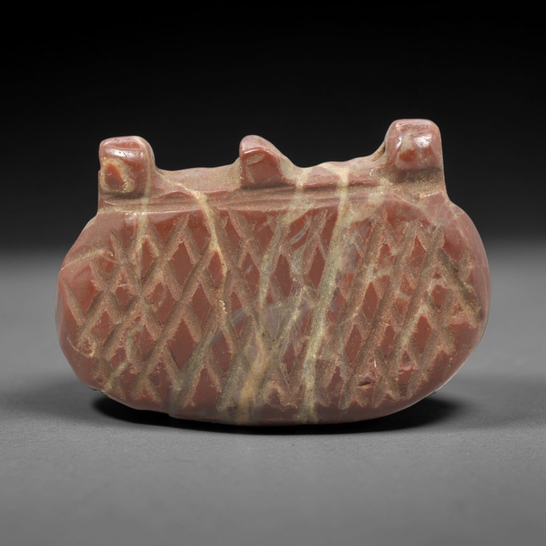 Ancient Jasper Basket Amulet - Near Eastern Protective Figurine, 30ZR: This artifact is a carved jasper basket amulet, executed in the stylized utilitarian tradition of the ancient Near East. The amulet depicts a compact basket form with a crisscross incised pattern acro