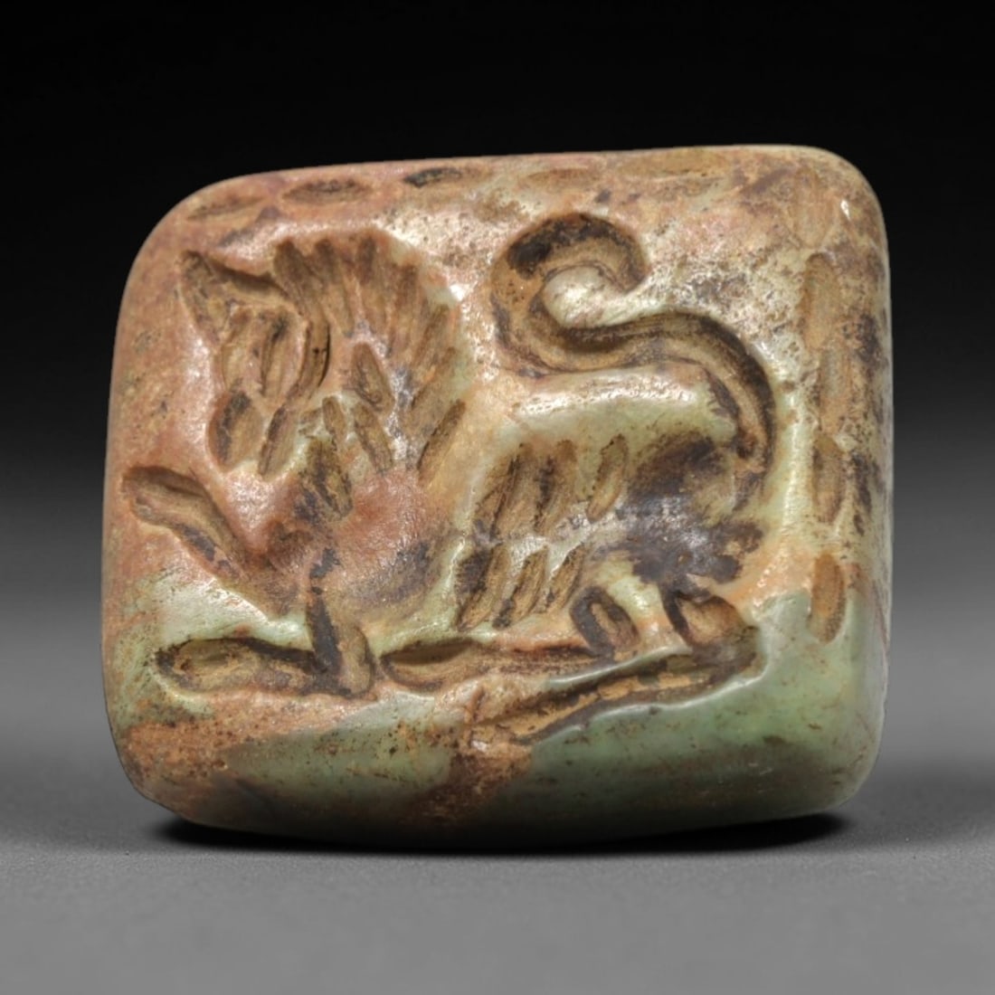 Ancient Jasper Griffin Stamp Seal - Near Eastern Figurine, 75ZP: This artifact is a carved jasper stamp seal, featuring a dynamic griffin motif executed in the stylized zoomorphic tradition of the ancient Near East. The seal's face depicts a griffin with outstretch