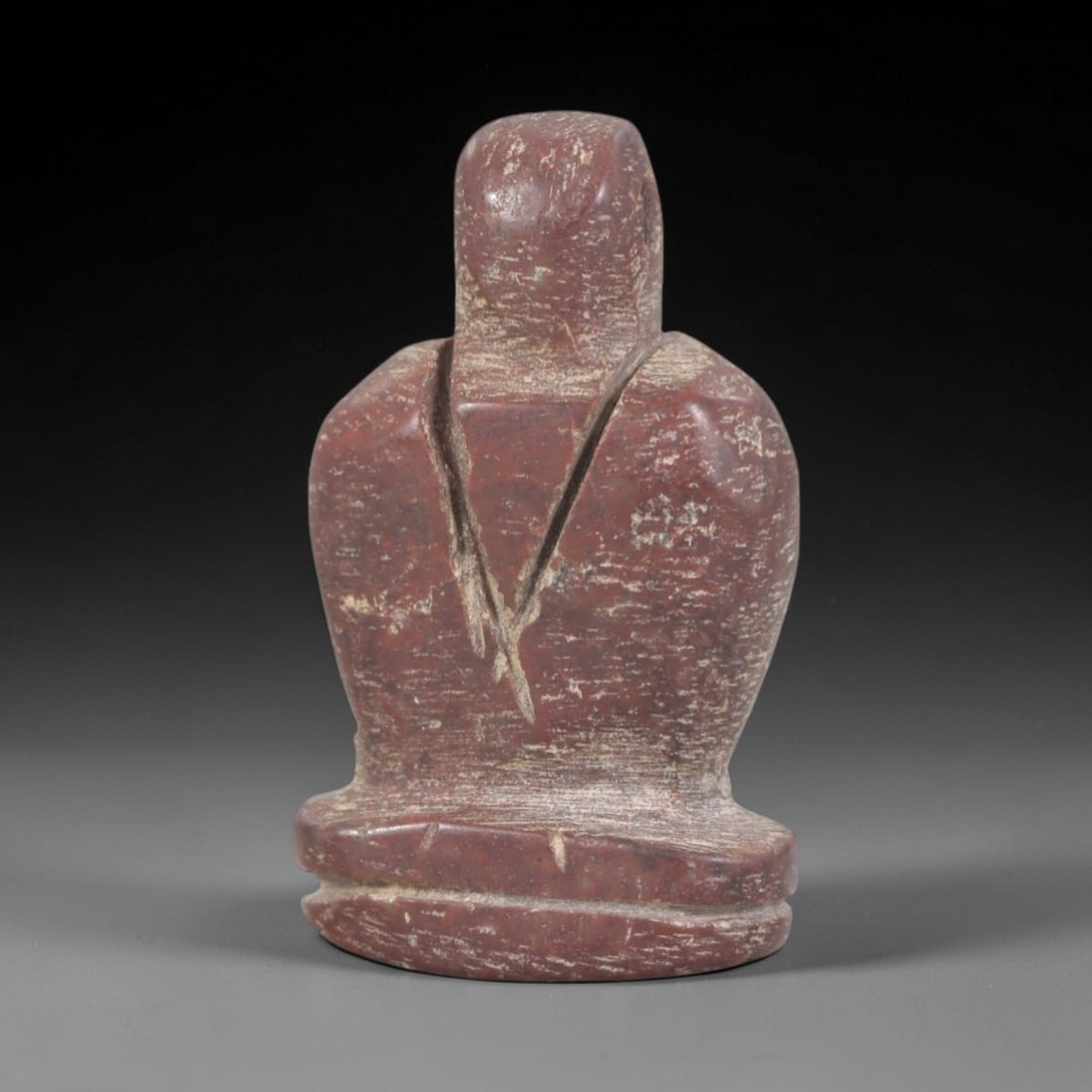 Ancient Stone Anthropomorphic Amulet - Egyptian Figurine, 44AP: Carved from a rich, reddish stone with natural mineral inclusions and a weathered patina, this amulet depicts a stylized anthropomorphic form with a simplified, rounded head, a torso defined by incise