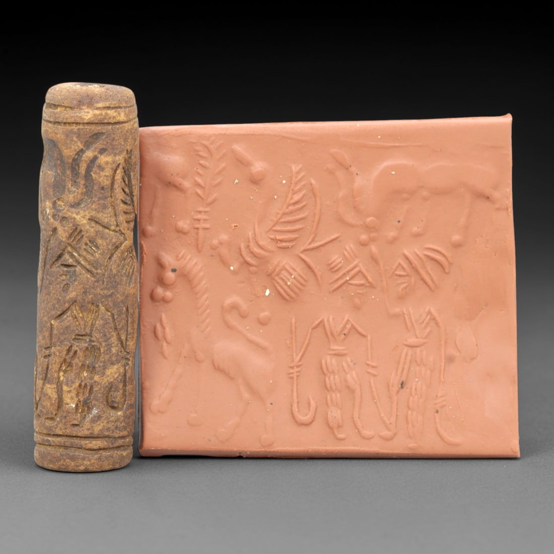 Ancient Steatite Cylinder Seal - Mesopotamian Animal & Figural Scene, 91ZR: Carved from dense steatite, this ancient Mesopotamian cylinder seal features a detailed linear relief composition of animal and human figures interwoven with botanical motifs, executed in the characte