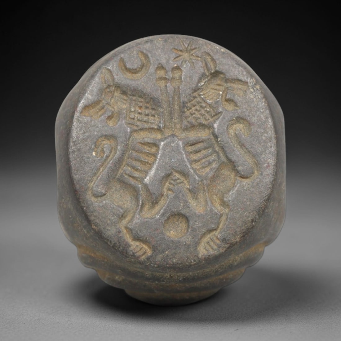 Ancient Stone Hemispherical Stamp Seal - Near Eastern Double Griffin, 57ZP: Crafted from a dense, reddish-brown stone, this hemispherical stamp seal bears a deeply incised composition featuring two symmetrically opposed griffin-like creatures, rendered in linear relief with d