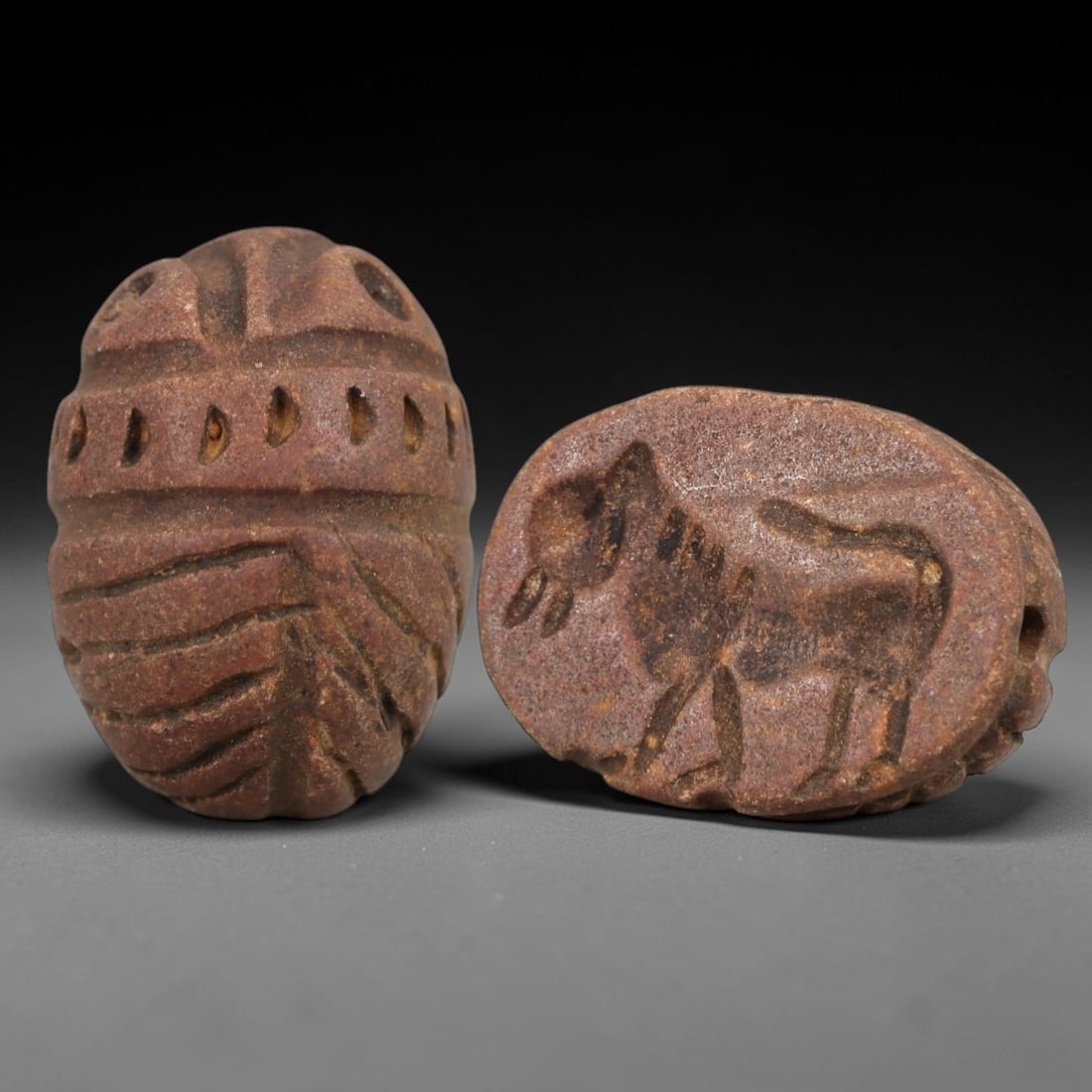 Ancient Steatite Scarab Stamp Seal - Near Eastern Donkey Figure, 76AM: Carved from reddish-brown steatite, this Near Eastern scarab stamp seal features a dorsal scarab pattern with incised linear wing segments and decorative perforations, while the ventral face depicts a