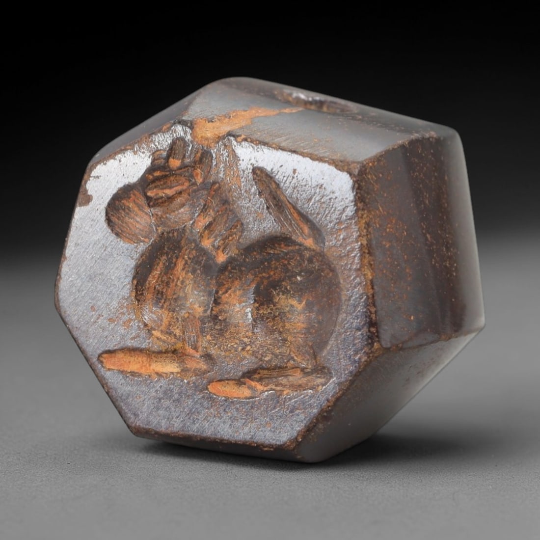 Ancient Hematite Conoid Stamp Seal - Near Eastern Amulet, 2AH: Carved from hematite, this ancient Near Eastern conoid stamp seal features a stylized animal motif typical of early glyptic art in the region. The piece exhibits primitive yet precise craftsmanship, w
